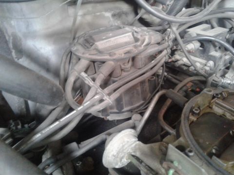 1984 Buick Electra - Close-up of an engine's distributor cap and spark plug wires, showing mechanical components.
