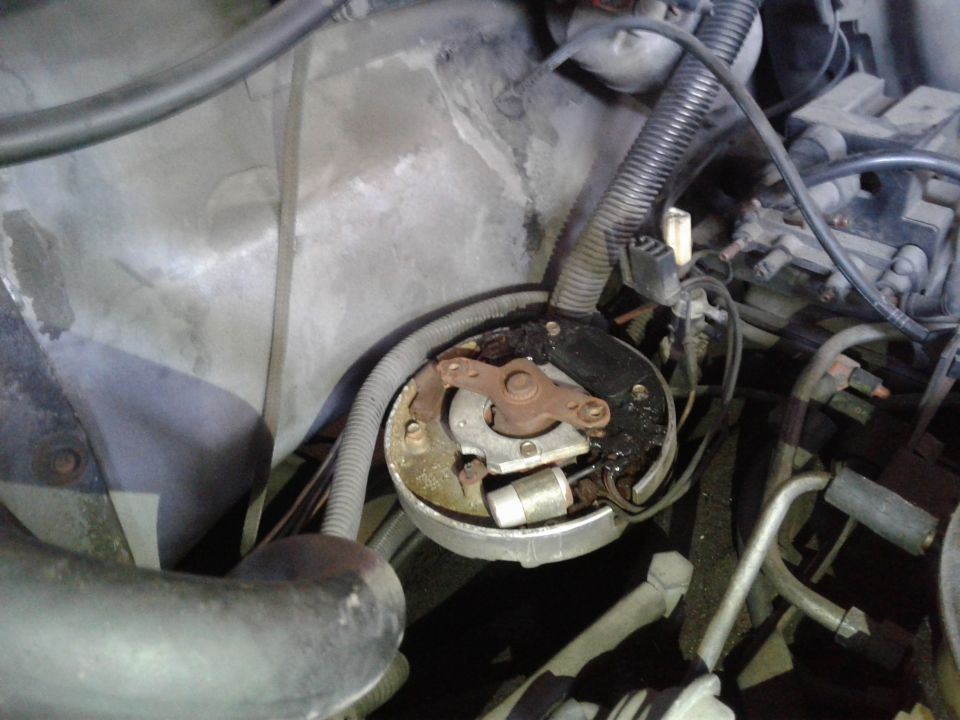Engine distributor cap with worn contacts and black residue
