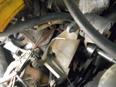 1992 Ford Bronco - A close-up view of the engine bay of a 1992 Ford Bronco, showing various hoses, wires, and mechanical components.