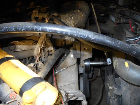 1992 Ford Bronco - A close-up view of engine components in a vehicle, showing a belt, pulley system, and various hoses. Text on a hose reads "MOISTURE GUARD P…