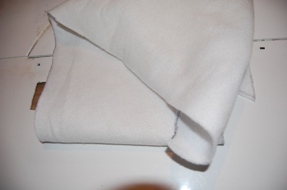 White batting or insulation folded over a white surface with a cut-out.