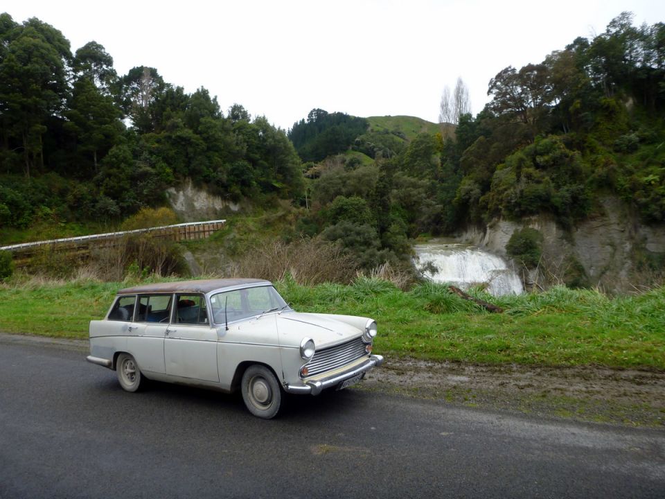 Austin A55 Cambridge Countryman parked on a road with a waterfall in the background