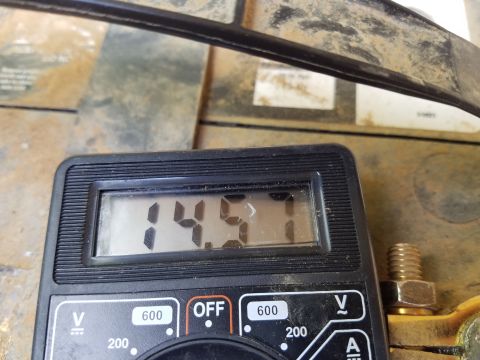 1988 Ford Bronco - A digital multimeter reads 14.57 volts while connected to a vehicle battery terminal. The multimeter dial is set to measure voltage.