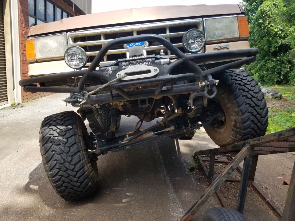 1988 Ford Bronco front end on a ramp with custom bumper and winch.