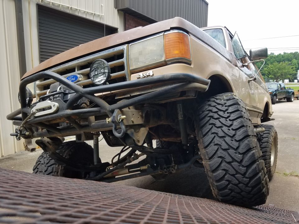 Lifted 1980s Ford Bronco with custom bumper and winch.