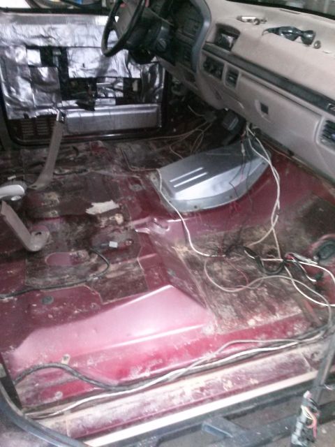 1996 Ford Bronco - The interior of a Ford Bronco is shown with the floor stripped bare for modifications. Sound deadening material is applied to the driver's…