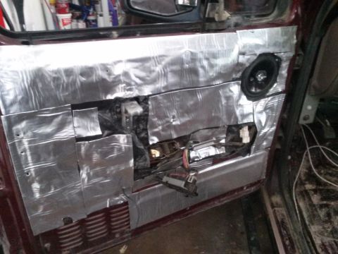 1996 Ford Bronco - The interior door panel of a vehicle, likely a 1996 Ford Bronco, has been partially disassembled and covered with sound-deadening material.…