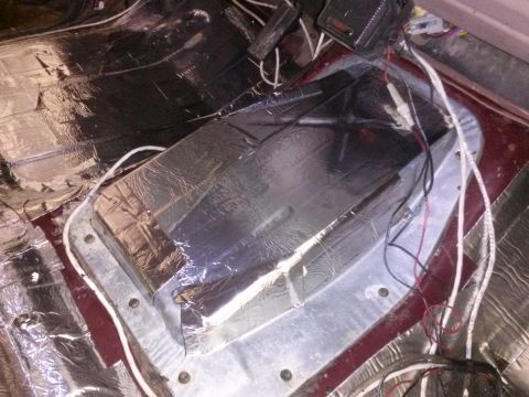 1996 Ford Bronco - The interior of a vehicle is shown with sound deadening material applied to the floor and a metal hump covered in foil tape. Wires and elec…