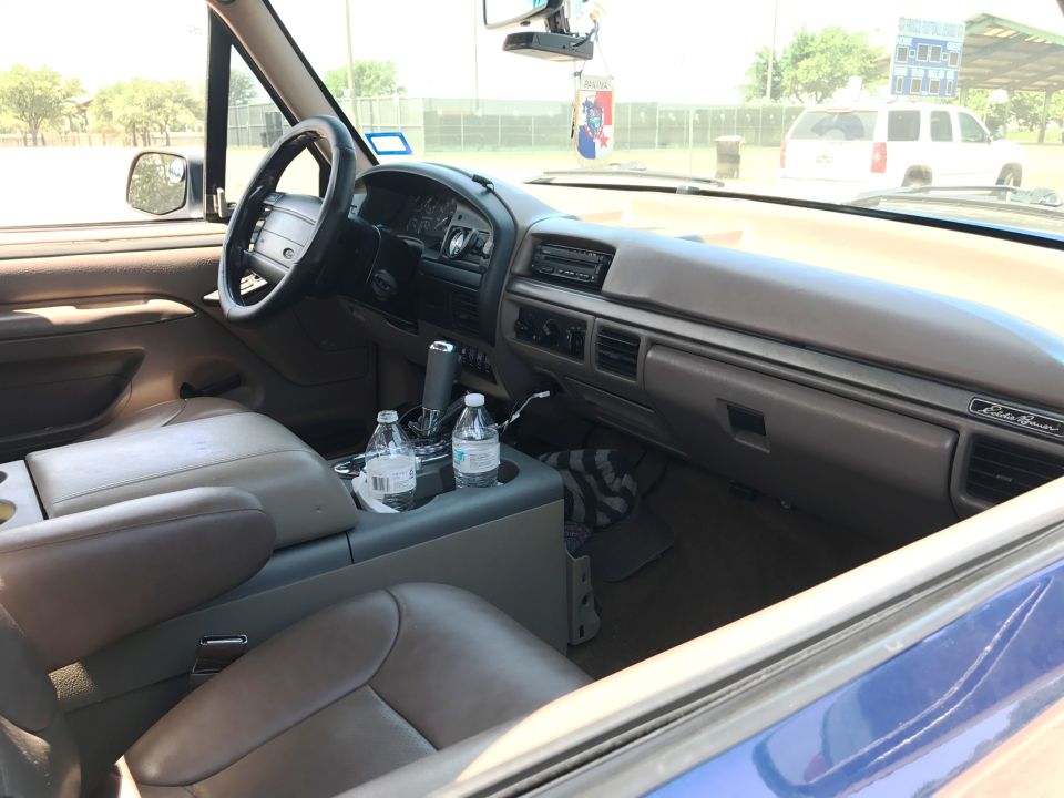 Interior of a 1996 Ford Bronco, showing dashboard, center console, and seats.