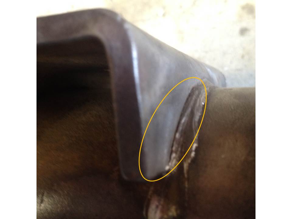 Close-up of a damaged dark brown metal part.
