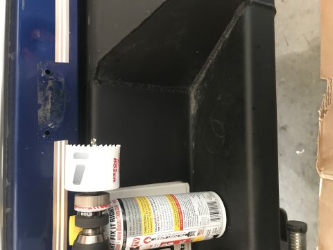 1996 Ford Bronco - A close-up view shows a hole saw attachment on a drill, positioned next to a can of spray lubricant. The background features a blue painted…
