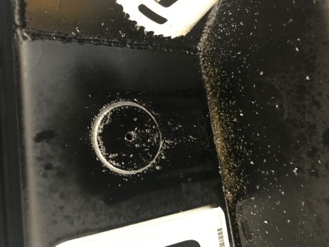 1996 Ford Bronco - A close-up view shows metal shavings around a freshly drilled hole in a black, painted metal surface, likely a vehicle frame or component.…