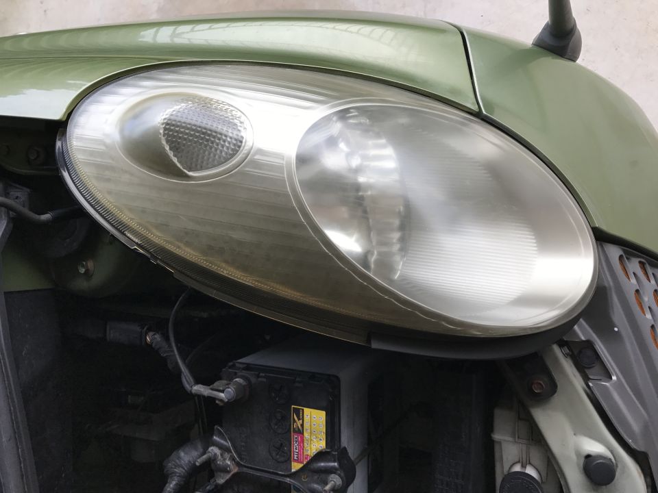 Green car driver's side headlight assembly with hazy lens