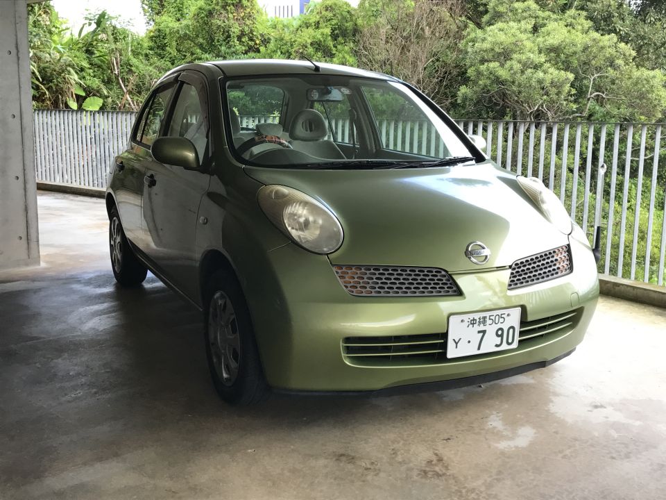 Front 3/4 view of a light green 2003 Nissan Micra parked in a covered area.