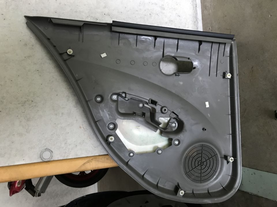 Interior of a gray car door panel with speaker grille