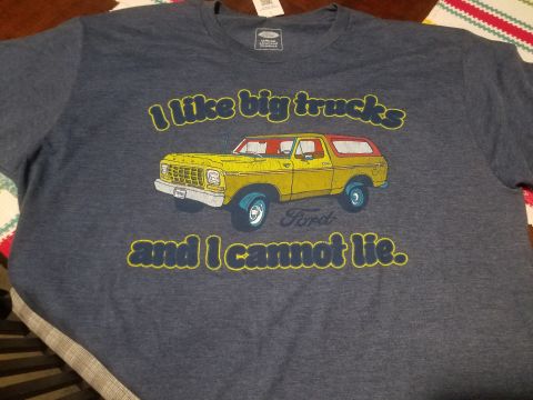 1988 Ford Bronco - A dark blue t-shirt featuring a graphic of a yellow 1978 Ford Bronco with the text "I like big trucks and I cannot lie."