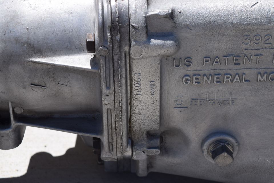 Close-up of a cast aluminum part with embossed text "US PATENT GENERAL MO" and part number "P1A06C".