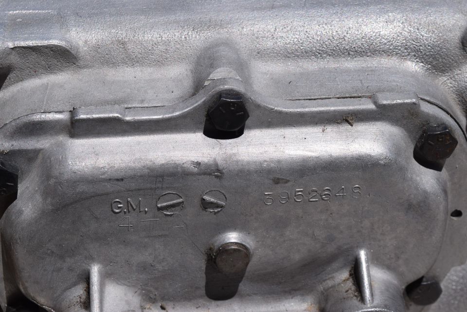 Close-up of a metal automotive part with GM and part number 3952648 stamped on it.