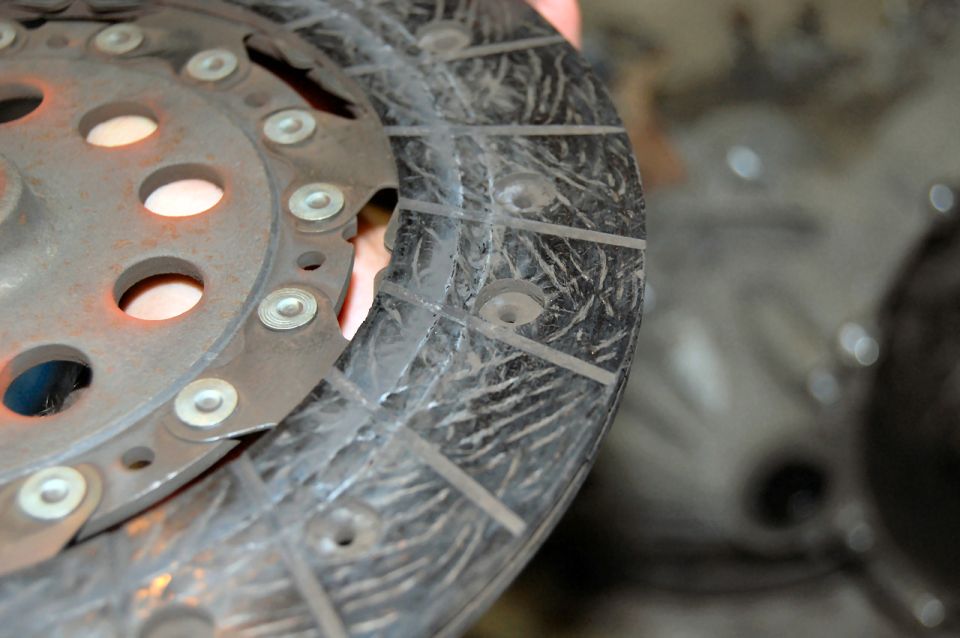 Worn clutch disc with rivets and metallic hub.