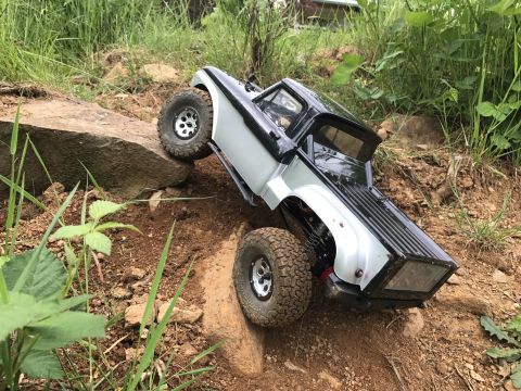 1989 Ford Bronco - RC rock crawler truck navigating a rocky, off-road course.