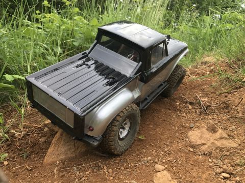 1989 Ford Bronco - Remote control truck with off-road tires navigates a rocky trail.