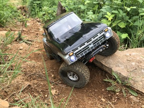 1989 Ford Bronco - RC rock crawler truck navigating a challenging rocky obstacle course.