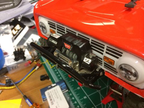 1989 Ford Bronco - A close-up of a red 1989 Ford Bronco model's front end, a black winch mounted on the bumper.