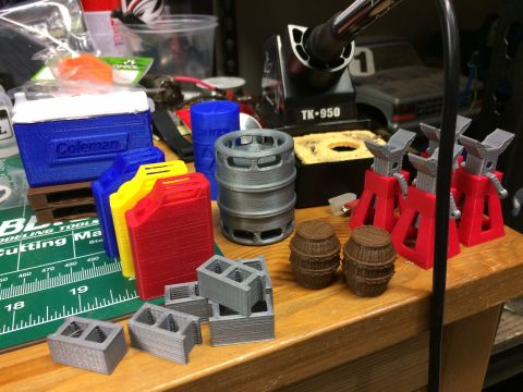 1989 Ford Bronco - A collection of 3D printed accessories for RC cars are displayed on a workbench next to a soldering iron.