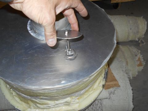 1992 Ford Bronco - A hand interacts with a metal component on a heavily insulated cylindrical object.