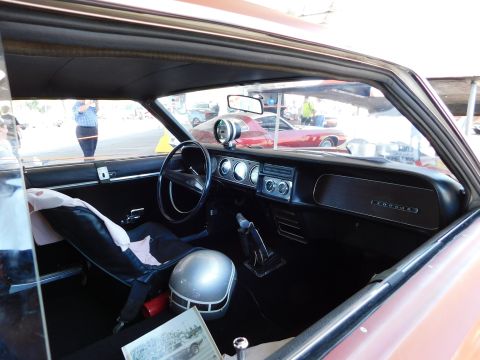 1968 Mercury Cougar - The interior of a 1968 Mercury Cougar is shown, a racing helmet and a glimpse of another vehicle outside.