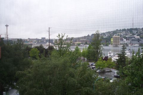 1995 Ford Bronco - View of Seattle skyline and waterfront with boats docked and cars parked in a lot.