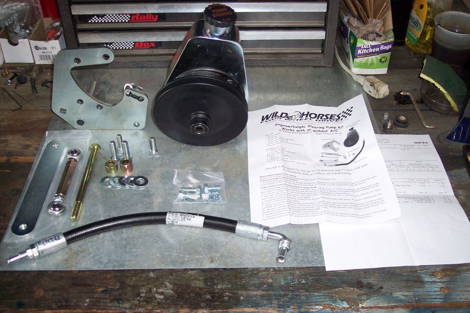 Power steering pump kit with instructions on a workbench.