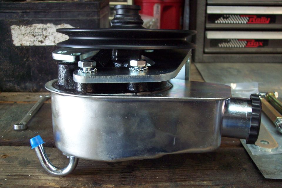 Power steering pump and pulley assembly on a wooden surface.