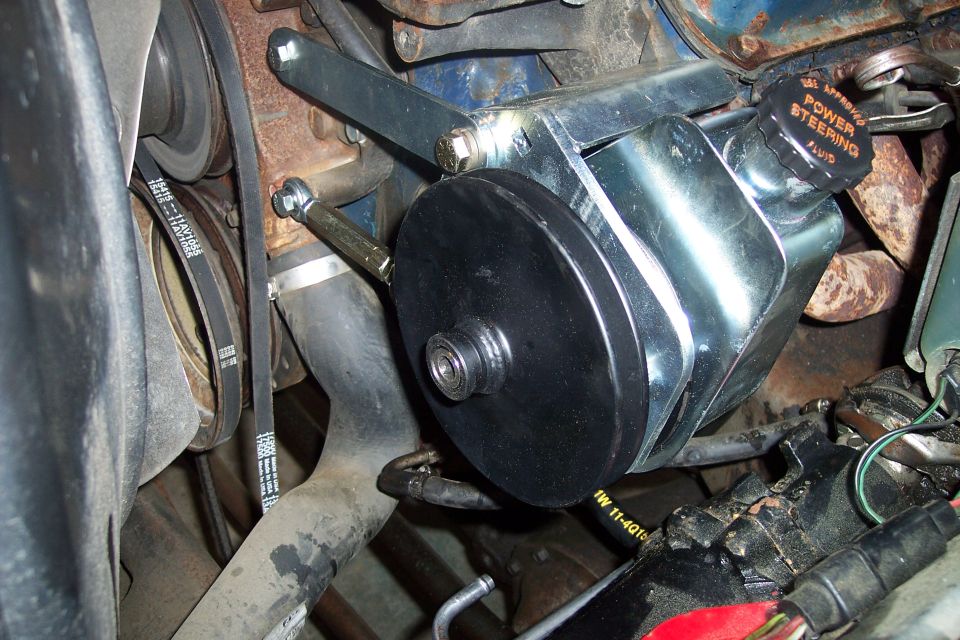 Close-up of a power steering pump assembly on an engine.
