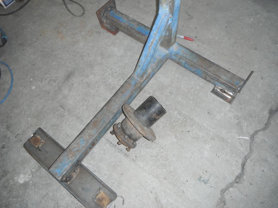 Blue metal frame with wheel hub assembly on concrete floor
