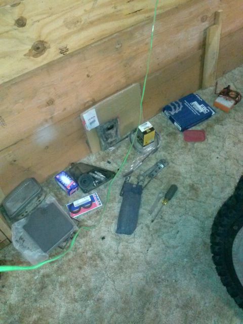 1987 Honda XL600R - Various motorcycle parts and tools are laid out on the floor, suggesting maintenance or repair work.