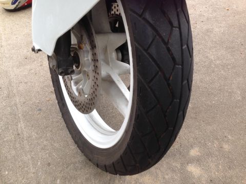 1989 Honda CBR600F - The front wheel assembly of a motorcycle is shown, including the tire, rim, and brake disc.
