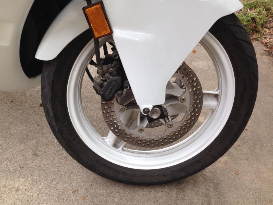 White 1989 Honda CBR600F front wheel with disc brake and caliper, viewed from the side