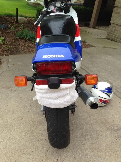 1989 Honda CBR600F - Rear view of a 1989 Honda CBR600F motorcycle with a towel draped over the fender and a helmet beside it.