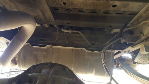 1978 Ford Bronco - The underside of a vehicle shows the exhaust system, fuel tank, and rear differential. The vehicle appears to be a truck or SUV with leaf s…