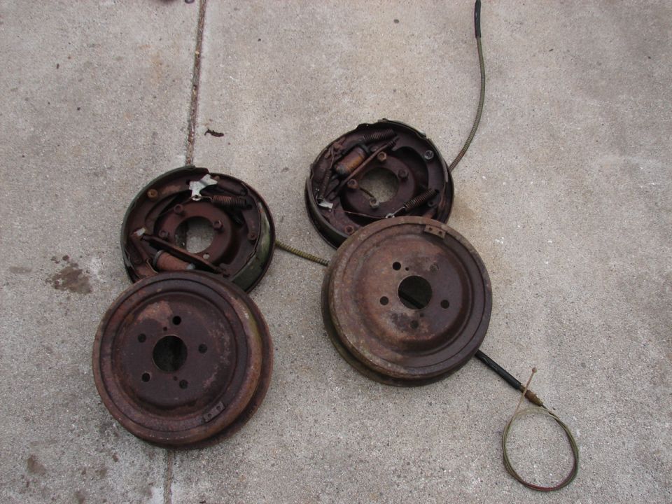 Rusty brake drums and brake shoes on concrete.