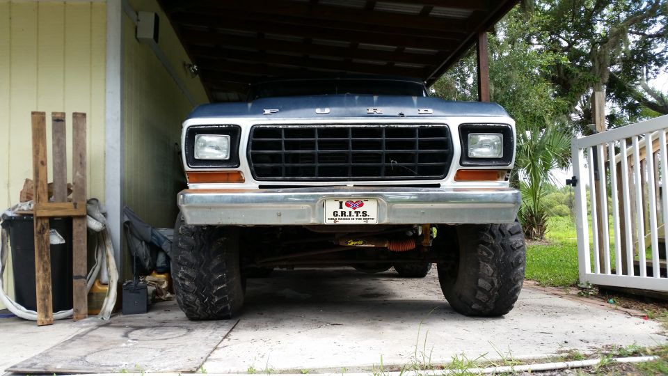 Lifted Ford truck front view with a "I Love GRITS" license plate.