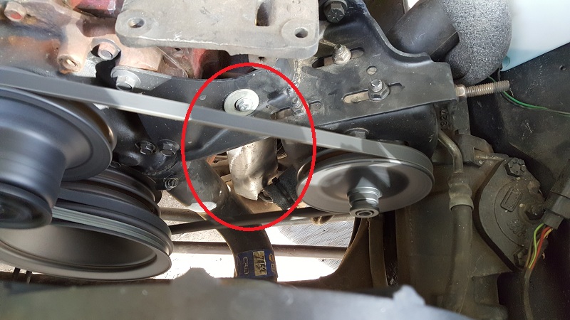 1978 Ford Bronco engine bay showing serpentine belt and pulleys, with a red circle around a bracket.