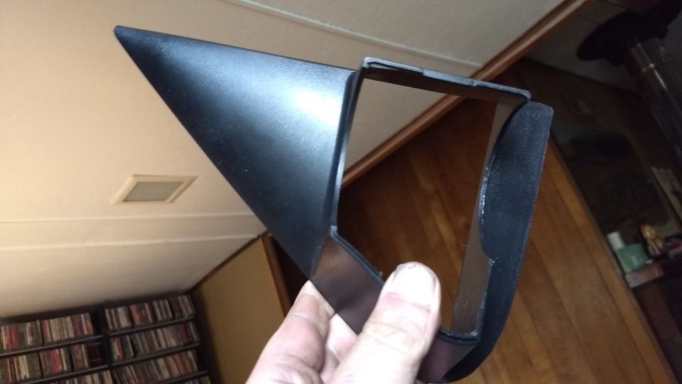 Black plastic automotive part held in hand