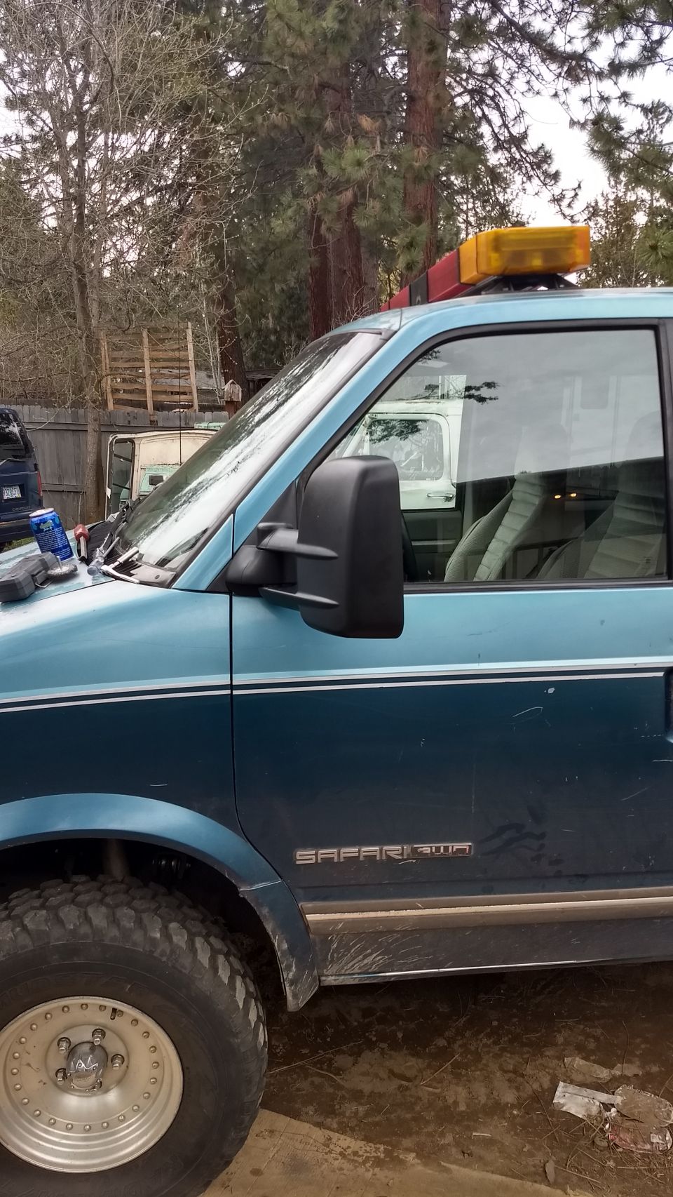 1995 GMC Safari van side view with off-road tires and roof light bar
