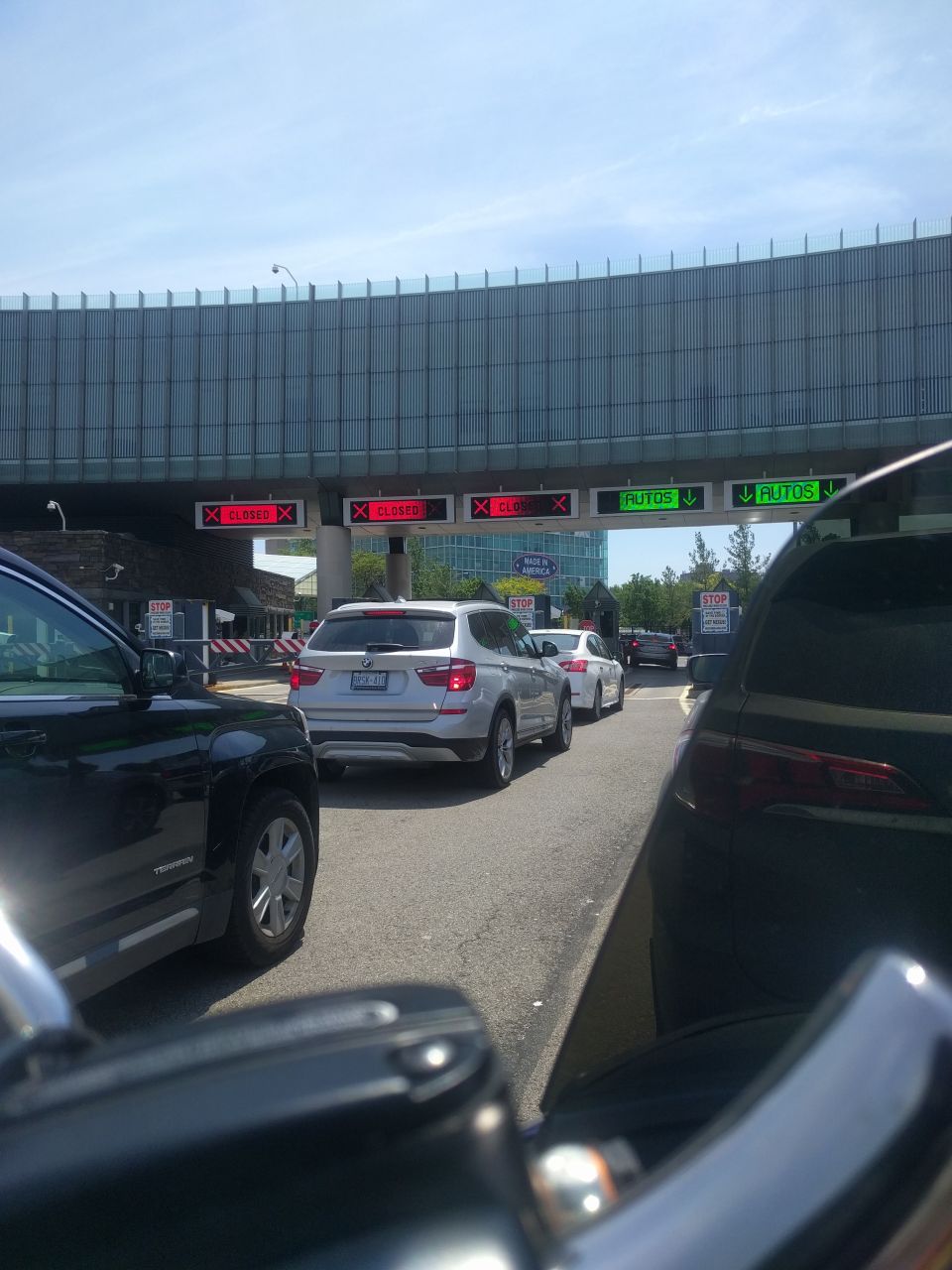 Cars stopped at a border crossing with closed and open lanes.