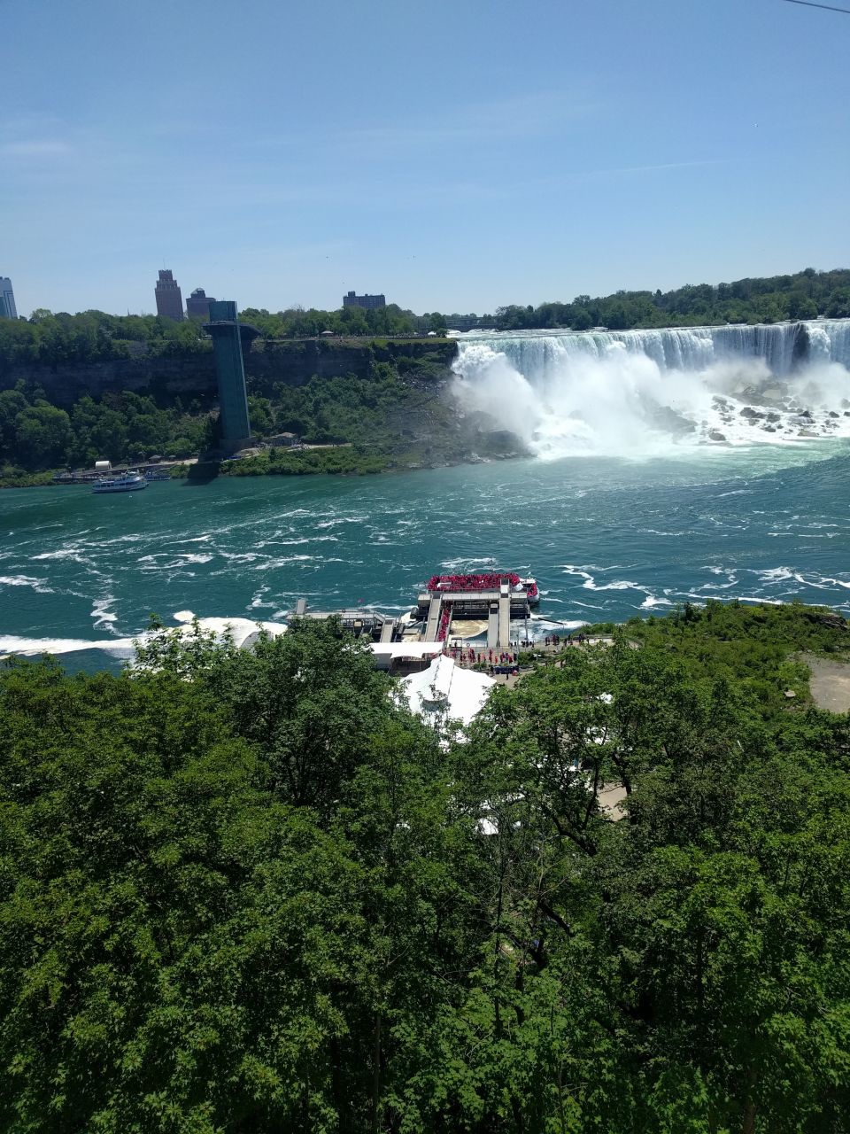Niagara Falls with a boat docked at the base of the falls.