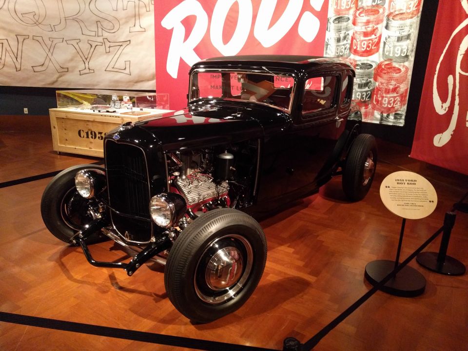 Black 1932 Ford hot rod with exposed engine and chrome details.