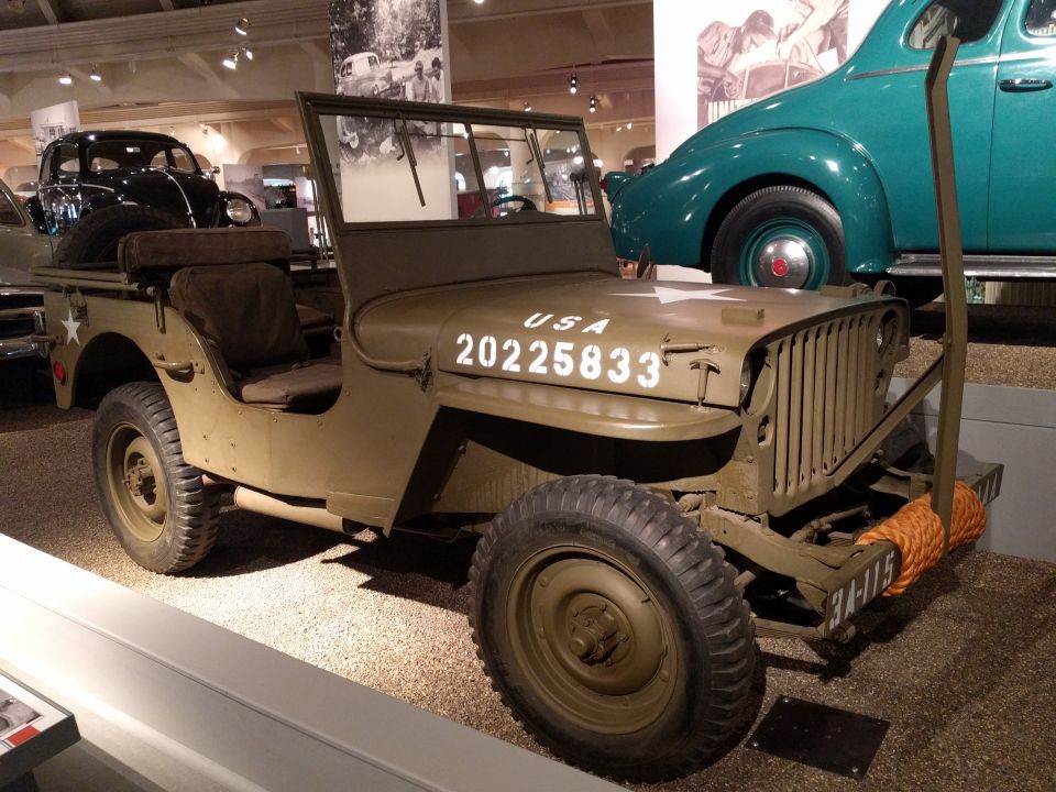Olive drab military Jeep with USA 25833 on hood, parked indoors.