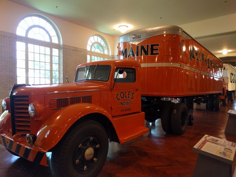 Vintage orange Coles Express truck with a silver-topped trailer.